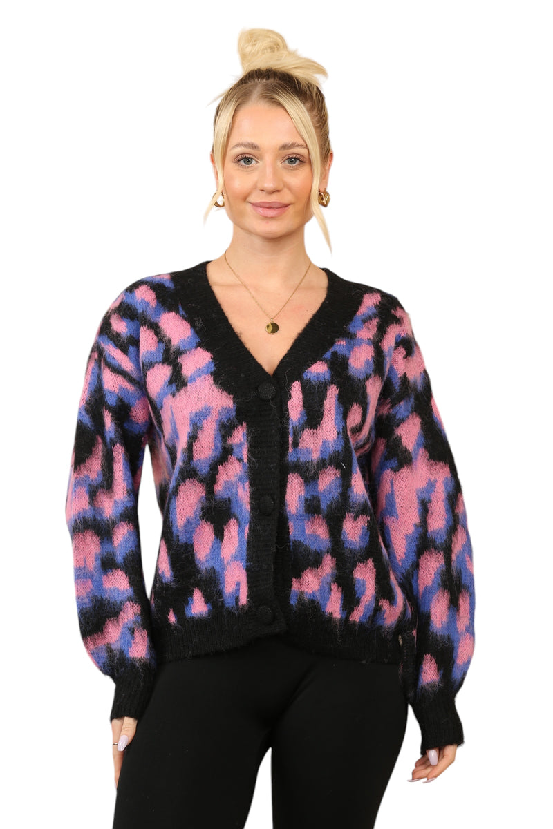 Model wearing a cosy multi-contrast print cardigan with pink, purple, and black abstract patterns,