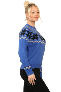 Model wearing a cosy blue Nordic-inspired jumper with a Fair Isle snowflake pattern in black and cream across the chest and sleeves