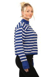 Model wearing a cosy blue and cream striped jumper with a mock neck, long sleeves, and a relaxed fit. The jumper is made of soft acrylic 