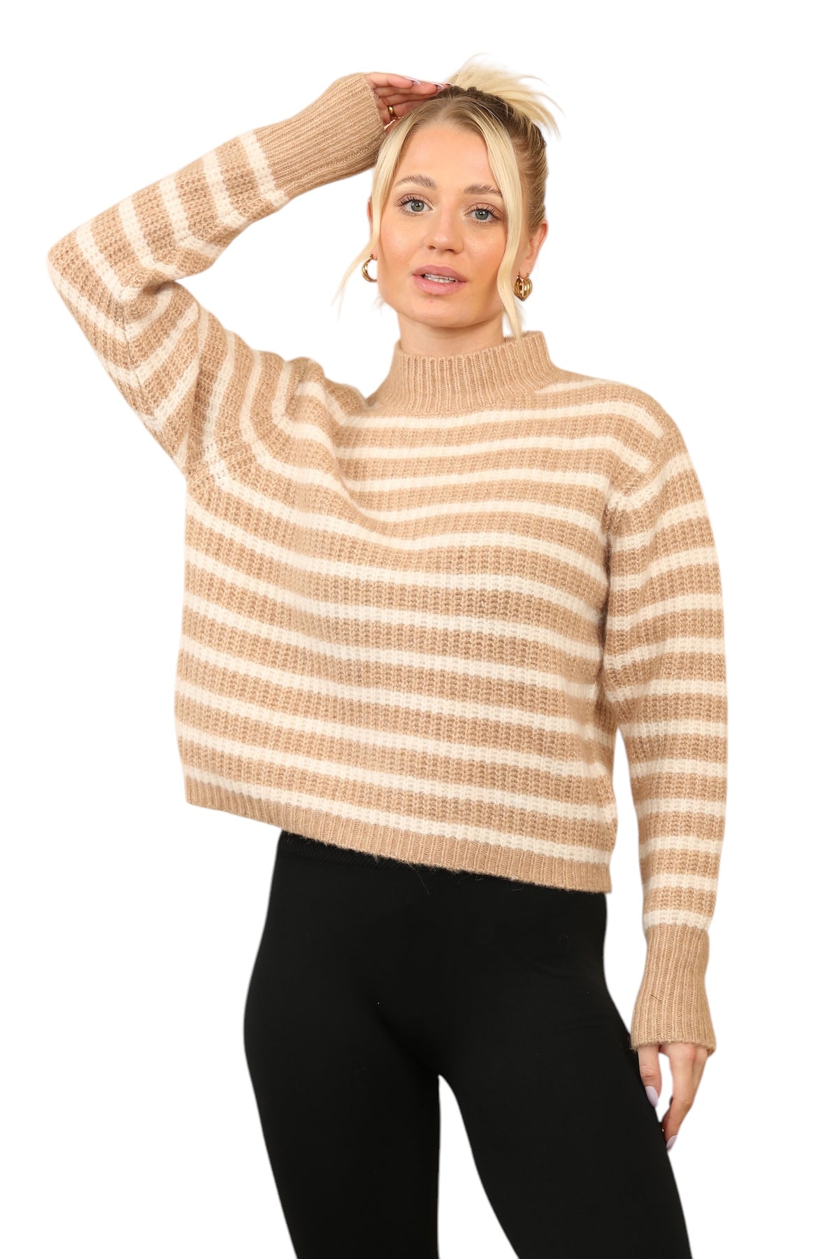 Model wearing a cosy beige and cream striped jumper with a mock neck, long sleeves, and a relaxed fit. The jumper is made of soft acrylic and styled with black leggings