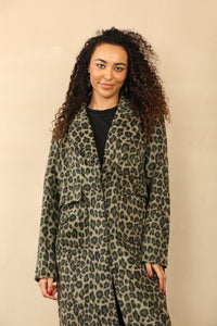 Model wearing a chic, longline leopard print coat with a classic lapel collar and deep pockets